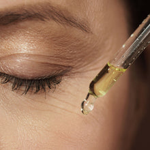 Load image into Gallery viewer, Close-up of a dropper releasing bakuchiol and rose geranium facial oil for skin hydration