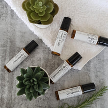 Load image into Gallery viewer, Truth Cosmetics natural vegan essential oil perfume roller bottles on gray surface with towel succulents and rosemary