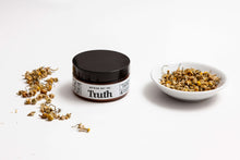 Load image into Gallery viewer, Truth Cosmetics jar with rosewood chamomile moisturizer for sensitive skin next to dried chamomile bowl
