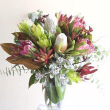 Load image into Gallery viewer, Protea and eucalyptus bouquet in clear glass vase used to represent Truth Cosmetics grapefruit cedarwood lotion and candle pack
