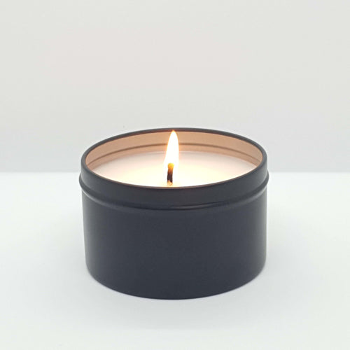 Truth Cosmetics1 coconut lime soy candle in matte black tin burning with single flame and white wax